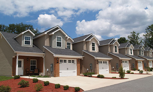 Row of townhomes with large driveways and entryways.