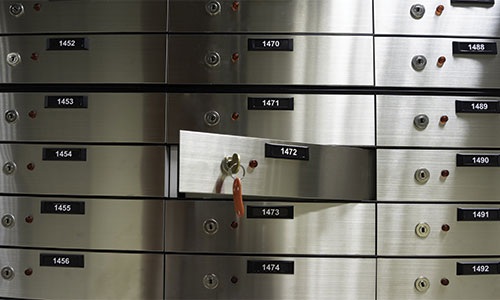 Numbered lock boxes with a key showing that one is open.